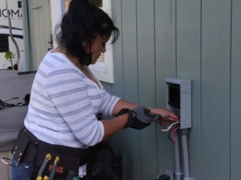 Licensed electrician wiring an exterior subpanel in Rockwall